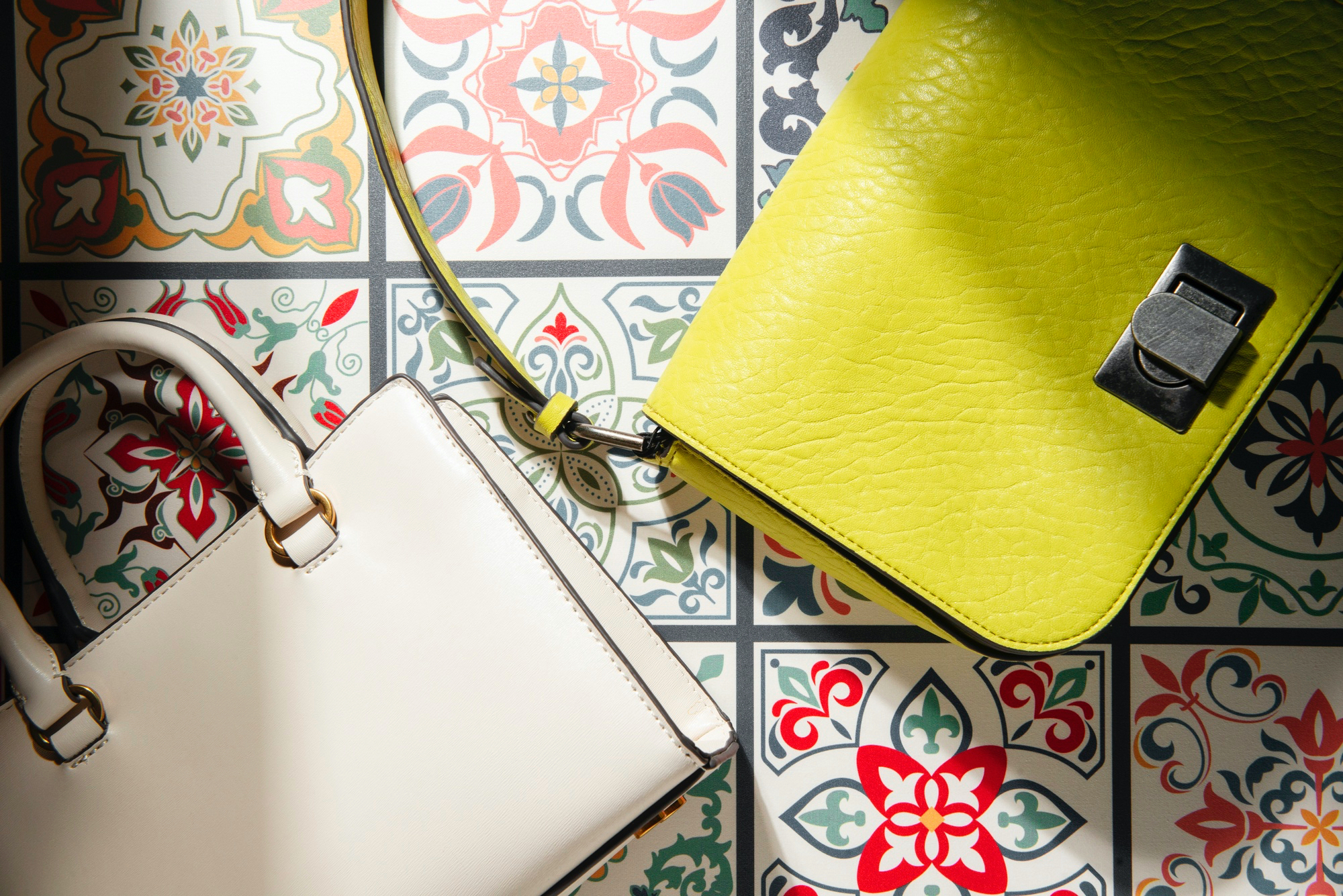 Cartera blanca y verde sobre un mosaico de cerámica.