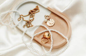 Accesorios varios de oro y perlas sobre una base de cerámica.