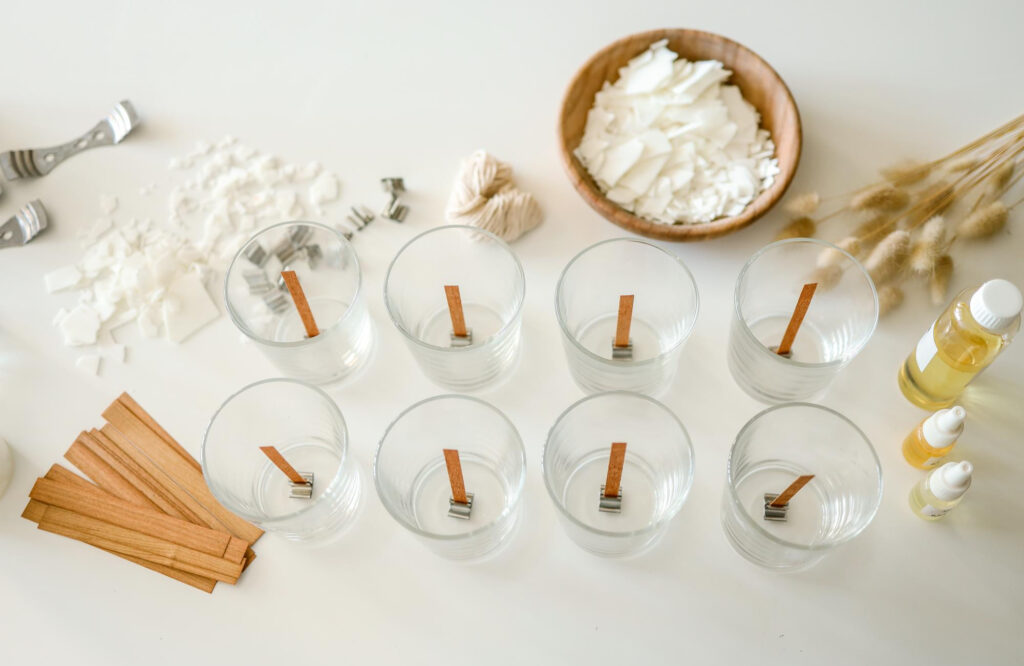 Velas Aromáticas. Crea tu propia vela. Elementos para hacer velas aromáticas en una superficie blanca.
