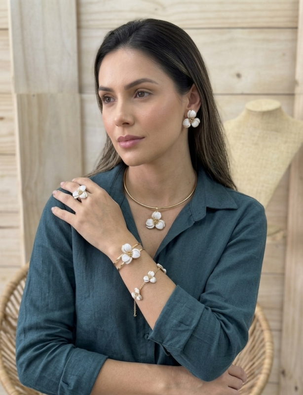 Joyas y Accesorios. Modelo luciendo un conjunto de aretes, collar, pulseras y anillo.