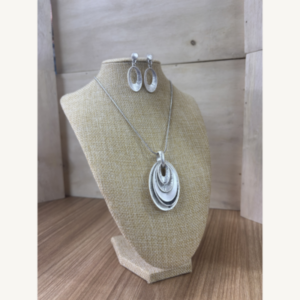 Bisutería y Accesorios. Conjunto de bisutería. Joyas, aretes y collar sobre un busto.